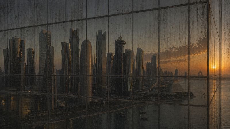 Dirty window with dust, streaks, and water spots obscuring the Doha skyline — before Clear Sky Drones cleaning